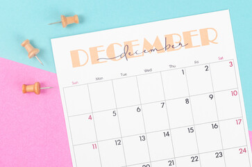 December 2022 calendar and wooden push pin on beautiful background.