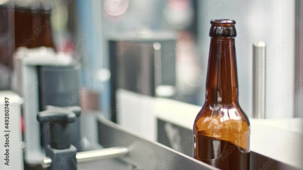 Poster empty brown bottles in a line in factory.