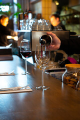 Pouring of dry Spanish tempranillo red wine in glass in Spanish bogeda restaurant