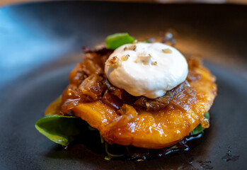 French starter dish tarte tatin of loaf with caramelized onions and whipped goat cheese