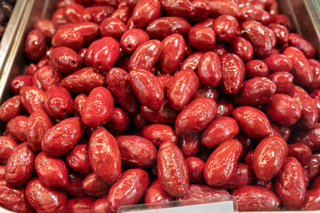 Red olives close up on market, food background