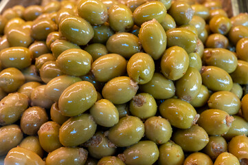 Green fresh olives close up on market, food background