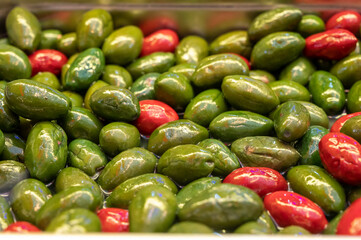 Green fresh green and red olives close up on market, food background