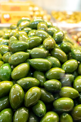 Green fresh olives close up on market, food background