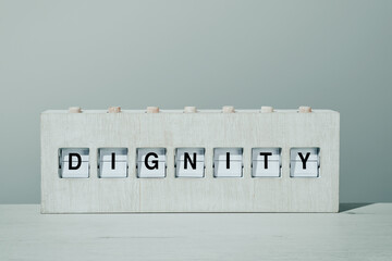 word dignity in a wooden split flap board