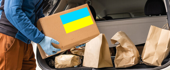 Collecting a humanitarian food set to help people who suffered during the war at the hands of Russia, stop the war in Ukraine, humanitarian aid 2022 - obrazy, fototapety, plakaty
