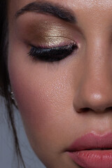Fototapeta premium Half close-up of beauty girl with long straight developing hair and radiant eveningtime makeup on her face. Skin care natural cosmetics in the spa salon or cosmetology.