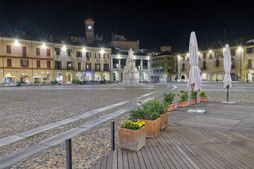 Traditional Italian historical square at night. Historic center of Vercelli. Square Cavour with the monument to Cavour of 1864 and the Angel tower (14th-17th century), symbol of the city   