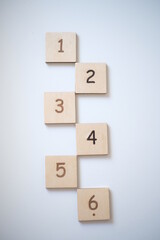 Wooden bricks with numbers on very white background. Educational toys. Top view image with space for text.