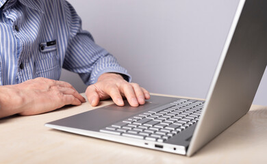 Man hand closeup on laptop touchpad. Using computer for information search, distant work and education, online shopping and booking, playing games and leisure. High quality photo