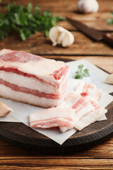 Tasty salt pork with parsley on wooden table