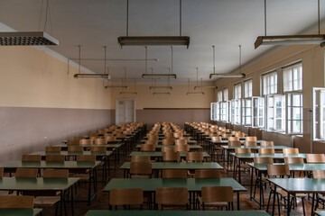 Fototapeta Empty old faculty or college School classroom with row of chairs, green desk tables and big white windows. Natural light. obraz