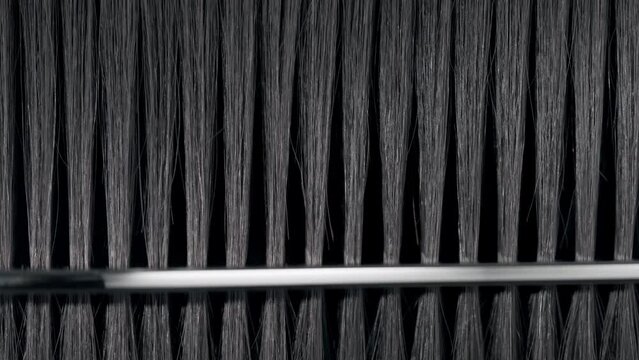 Black hair being combed with silver comb | Hair loss treatment concept