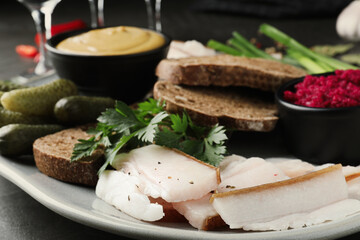 Tasty salt pork with rye bread and sauces served on table, closeup