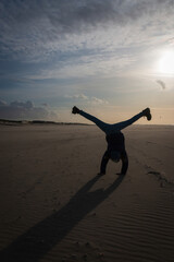 Girl doing a cartwheel on a beach