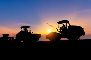 Silhouette of heavy wheeled tractor, grader, compactors and other construction machinery in the...