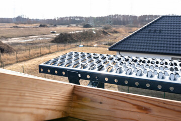 A chimney sweep bench on the roof of a single-family house covered with a new anthracite ceramic...