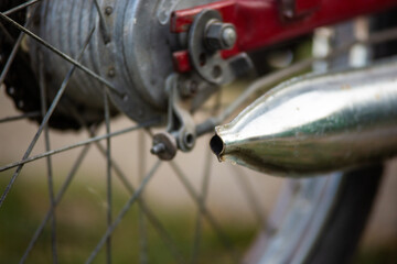 close up of a vintage motorcycle wheel and exhaust