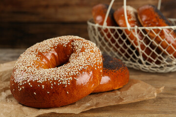 Delicious fresh bagels with poppy and sesame seeds on wooden table