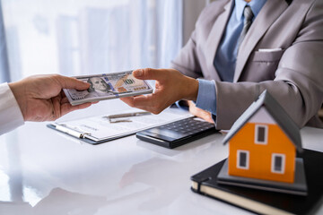 Paying for a Home with a Real Estate Agent, business man paying money to buy or deposit the house to a realtor or real estate agent