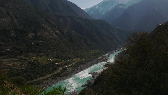 River Running Through Swat Valley Floor. Circle Dolly Reveal From Bush