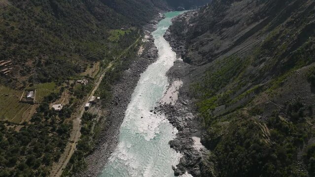 Aerial Over Flowing Turquoise River At Swat Valley. Tilt Up Reveal Of Distant Mountains