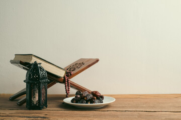 The Holy Al Quran with written Arabic calligraphy meaning of Al Quran and rosary beads or tasbih,