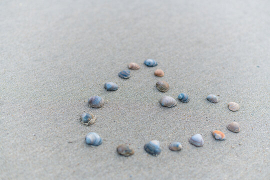 A heart is drawn in the middle of the sand by  Juist and depicted with shells