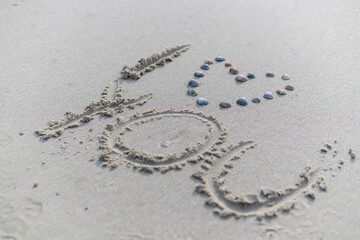 A heart with shells and  i love you was written in the sand