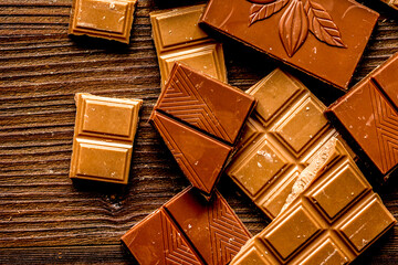 chopped chocolate pieces for dessert wooden desk background top view