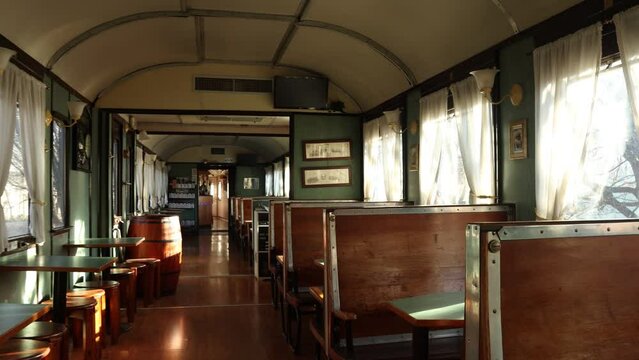 Panning fpv shot of vintage train transformed in restaurant. Handheld