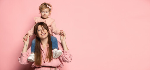Flyer with happy woman and little girl, caring mother and daughter isolated on pink studio background. Mother's Day celebration. Concept of family, childhood, motherhood