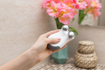microcurrent facial toning device in female hand. Concept of wellness, beauty and skincare. closeup