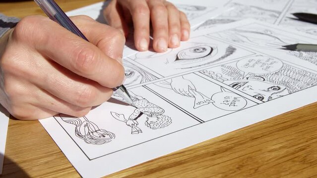 The artist draws a storyboard of comic book characters on sheets of paper.