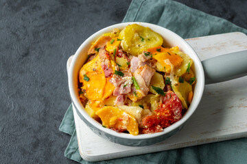 Casserole of potatoes, sweet potatoes, zucchini, tomatoes, onions and bacon