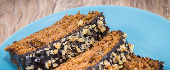 Homemade pastry made of zucchini with nuts and raisin on blue plate. Wooden background