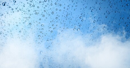 Rain drops on blue glass window with fog background.
