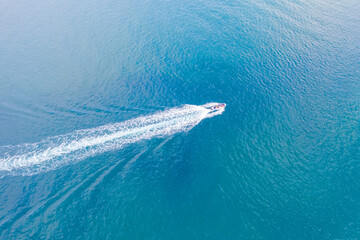 Top view of a white boat with a train sailing to the blue sea.