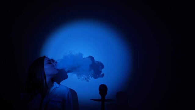 Smoke from the hookah is blue, the girl smokes, the image of the circle is light