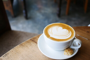 a cup of late coffee with heart shape design on top at cafe 