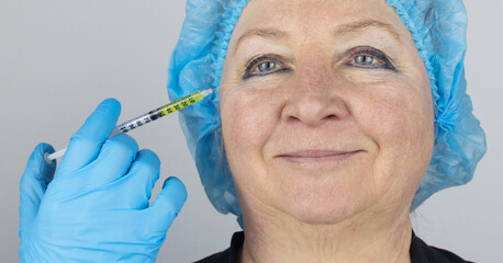 Botulinum toxin injection. Senior woman at the appointment with a beautician who is preparing to...