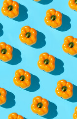 Abstract top view background of fresh yellow vegetables pattern on vibrant blue background, healthy eating and vegan concept