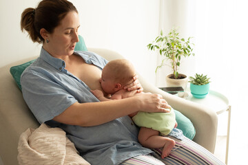 Mothed and baby, breastfeeding in laid back position - obrazy, fototapety, plakaty