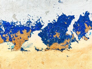 surface of the old cement wall is painted white and blue, peeling off and cracking.