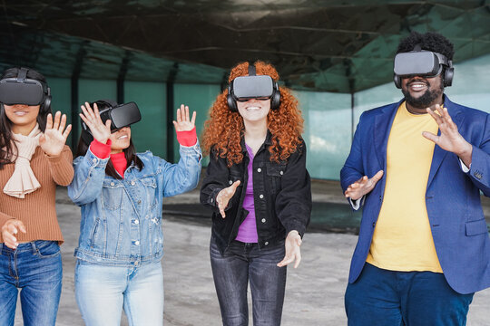 Young people having fun using virtual reality goggles outdoor