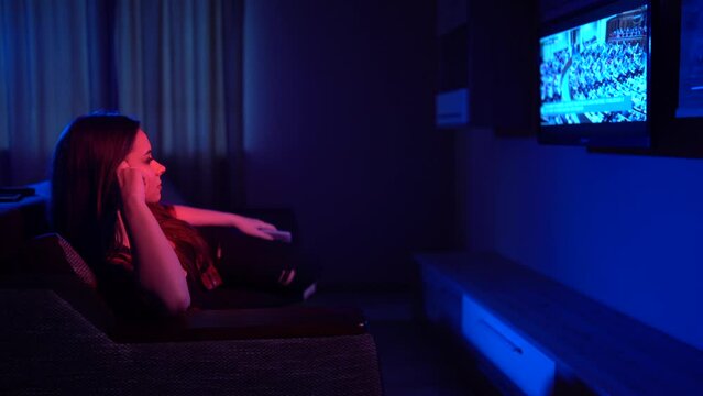  girl sitting on a sofa watching a movie on TV