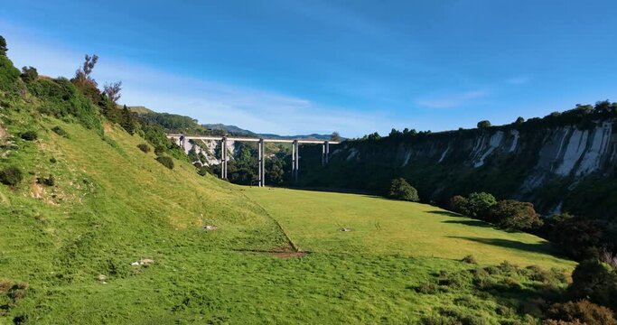 Flight towards South Rangitikei Viaduct over lush fields farm - New Zealand