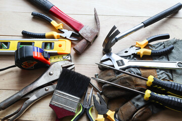 Hardware tools, equipment used for repair and maintenance work in general technicians isolated on wooden background closeup.