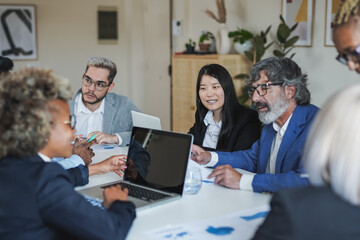 Multiracial business people working inside meeting room office using computer laptop - Focus on the asian girl