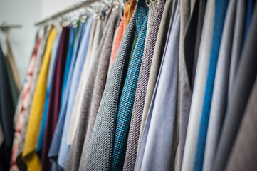 selection of textiles and leather for upholstery hanging on hooks in the showroom